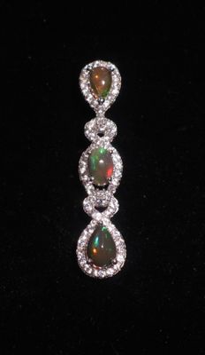 un gros plan sur une paire de boucles d'oreilles en oplite et en diamant