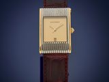 an image of a gold and brown watch on a blue background