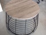 une table ronde avec un plateau en bois dans une pièce
