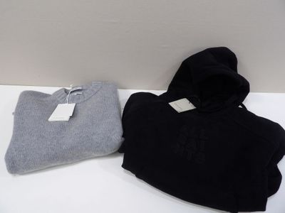 two pairs of black and grey sweaters sitting on a white table