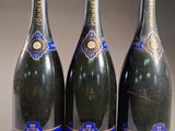 trois bouteilles de champagne posées côte à côte sur une table