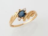 a close up of a gold ring with a sapphire and diamonds