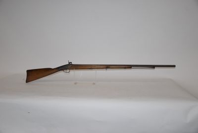 a rifle on a table with a white background