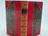 un vieux livre à la couverture rouge et à la bordure dorée