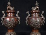 pair of bronze vases with birds and flowers on them