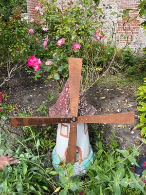 a statue of a windmill in the middle of a garden