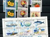 plusieurs timbres différents représentant des fleurs et des poissons sur un fond noir