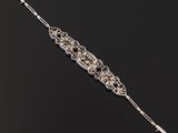 a close up of a silver bracelet on a black surface