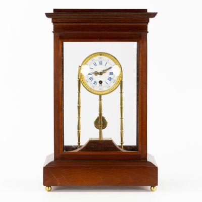 une petite horloge en bois surmontée d'une vitrine
