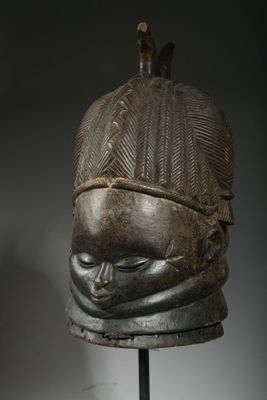 a close up of a wooden mask on a stand