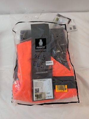 two pairs of orange pants sitting on a bed