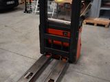 a fork lift truck parked in a warehouse with pallets