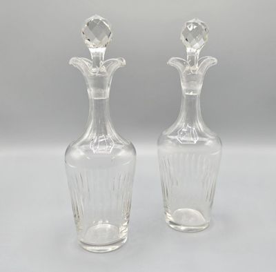 une paire de vases en verre transparent posés sur une surface blanche