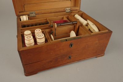 une boîte en bois contenant du matériel de couture