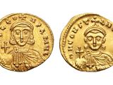 a gold coin with a portrait of a man and a woman on it