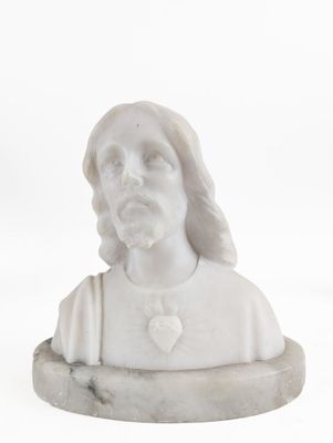 marble bust of a man with long hair wearing a white shirt