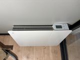 a heater that is sitting on the floor in front of a window