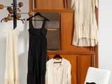 une photo d'un salon avec des vêtements suspendus à un portant