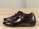 dark brown leather shoes with laces on a wooden surface
