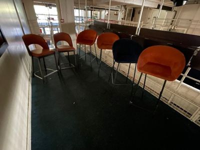 four orange and black chairs in a row in a room