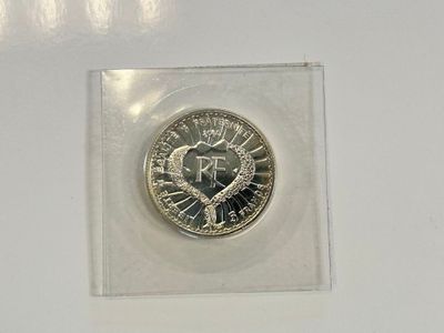 la pièce se trouve dans un étui en plastique transparent posé sur une surface blanche