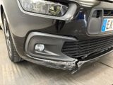 a car that has been dented and is parked on the side of the road