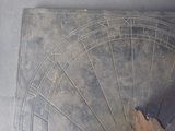 a sundial with a bird on it on a table