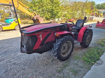 un tracteur rouge garé sur le bord de la route