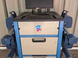 a computer sitting on top of a cart in a garage