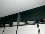 many bowls and cups on the shelves in the kitchen