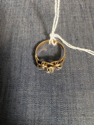 un gros plan d'une bague en or posée sur un tissu bleu