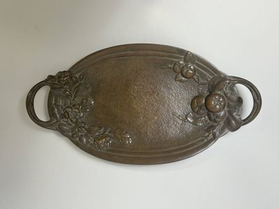 une plaque métallique ornée de fleurs et de feuilles