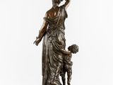 a bronze statue of a woman holding a child