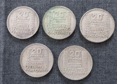 quatre types différents de pièces d'argent posées sur un tissu bleu