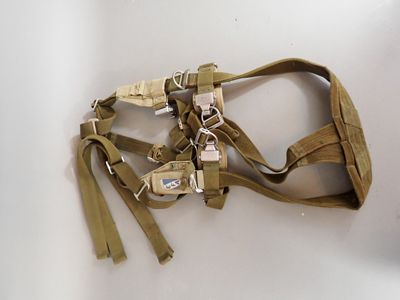 a tan harness on a white table with a key