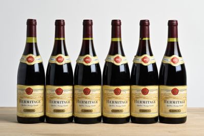 six bottles of wine are lined up on a wooden table