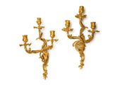 pair of antique brass wall sconces on a white background