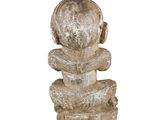 a stone sculpture of a man sitting on top of a pile of rocks