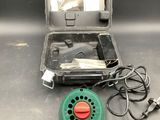 a green blow dryer sitting on a table next to a case