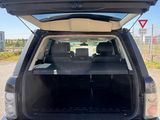 the back end of a black suv with its trunk open