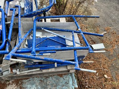 a pile of blue pipes sitting on the side of the road