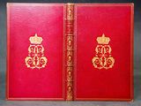 un vieux livre rouge aux tranches dorées, avec une couronne sur la couverture