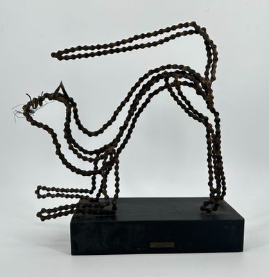 une photo d'une sculpture représentant un chien, réalisée à partir de chaînes