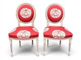 une paire de chaises rouges et blanches ornées de fleurs blanches