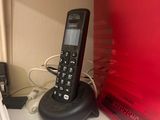 a phone that is sitting on a stand next to a microwave