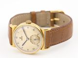 an image of a gold wrist watch with a brown leather strap