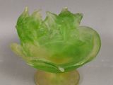 un bol en verre vert orné d'un motif de feuilles