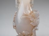 un vase blanc avec des fleurs posé sur une table