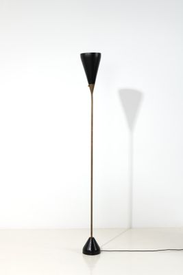 un lampadaire noir posé sur un sol blanc