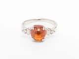 un gros plan d'une bague sertie d'une pierre orange